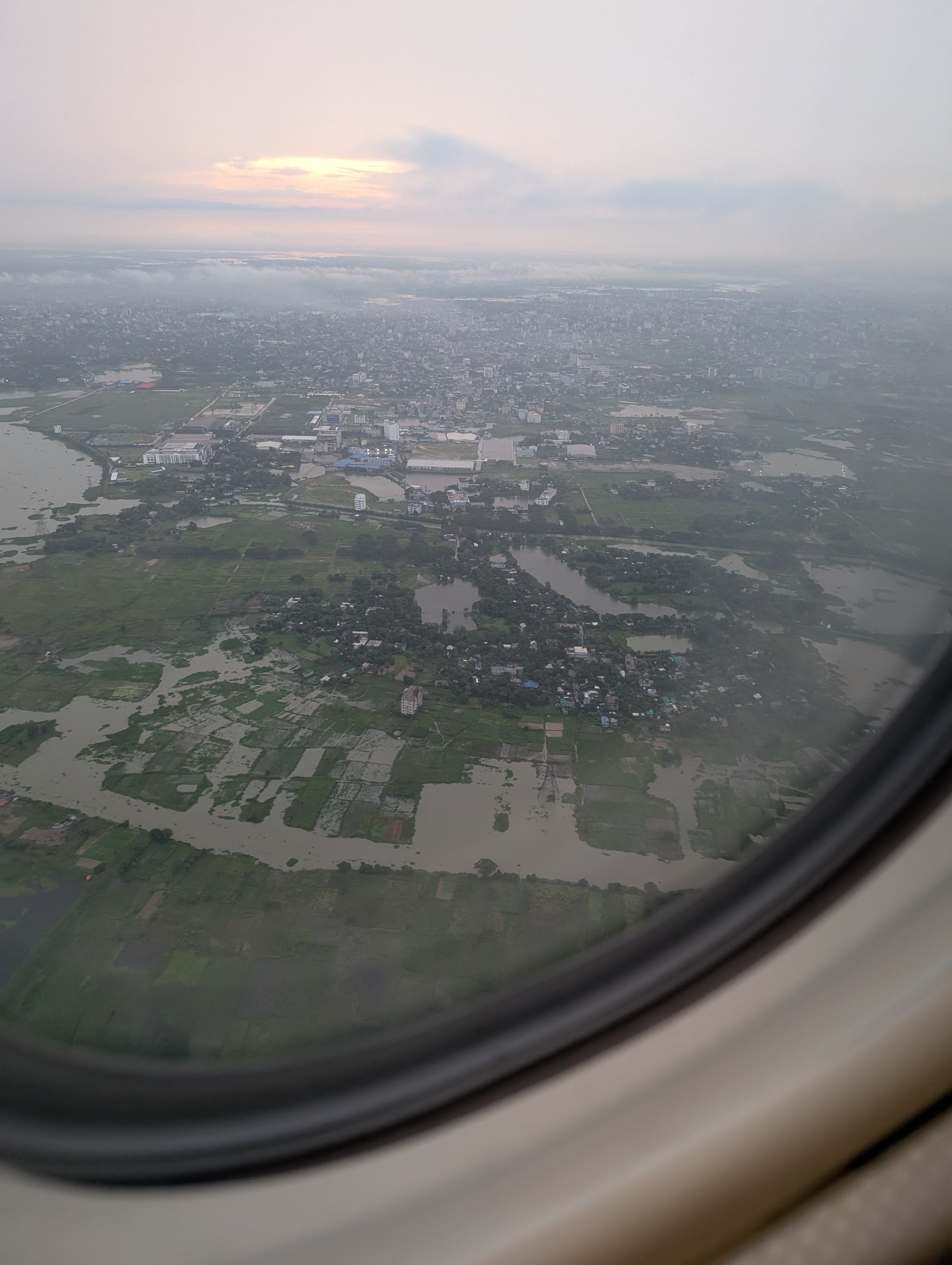 Blick aus dem Fenster eines Flugzeuges auf grüne Landschaften